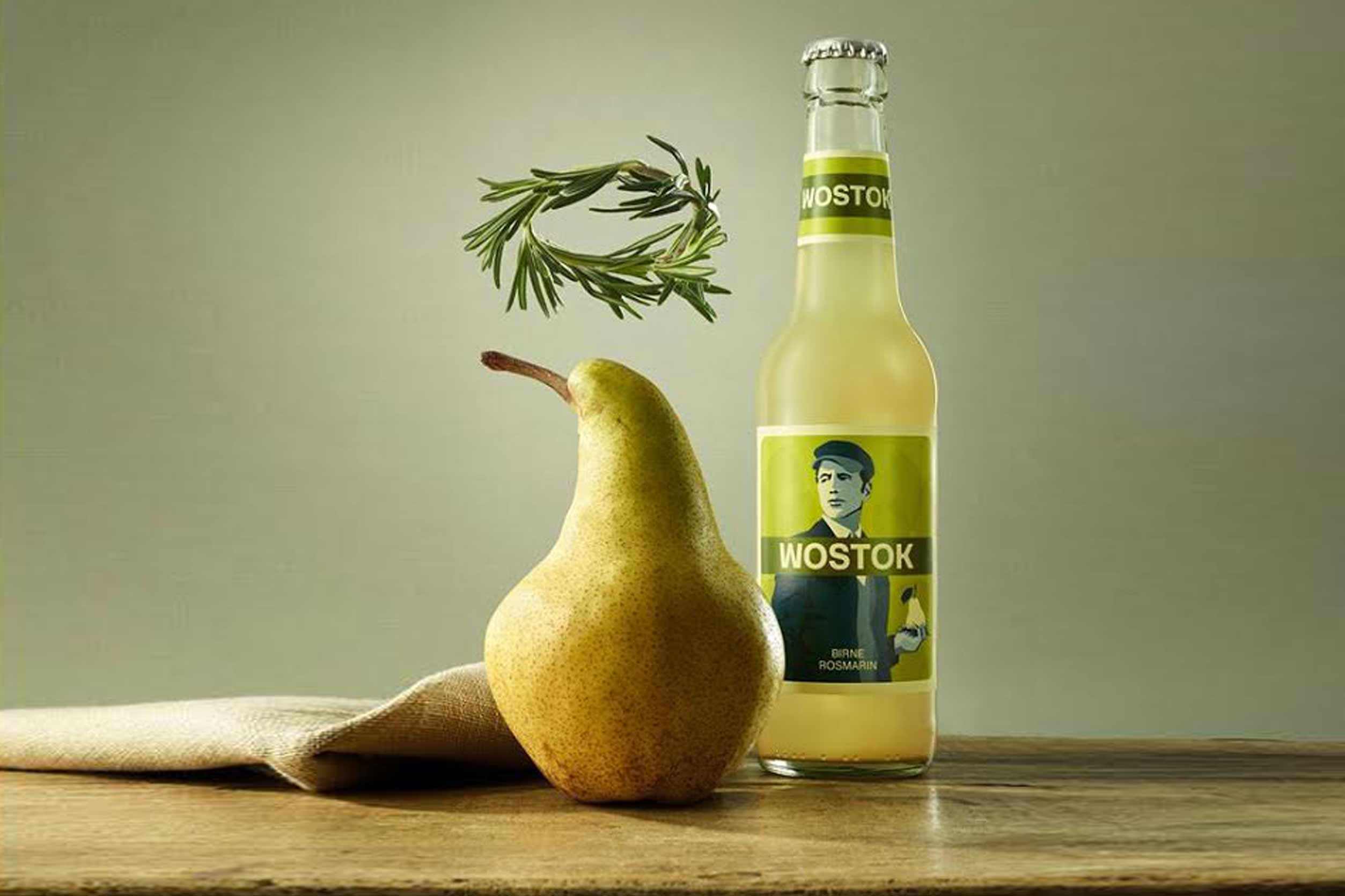Fles Wostok frisdrank naast een peer