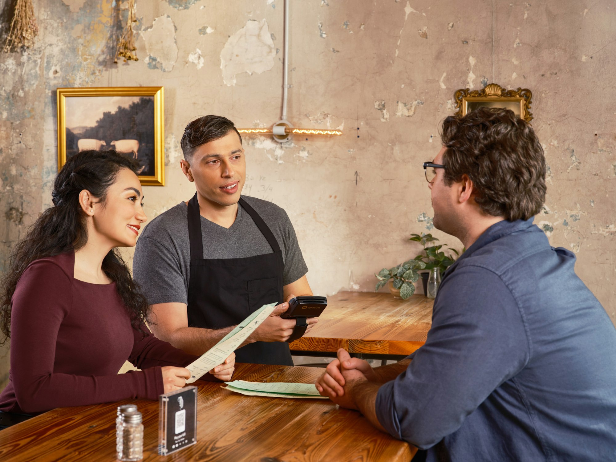 Ober in gesprek met gasten aan tafel